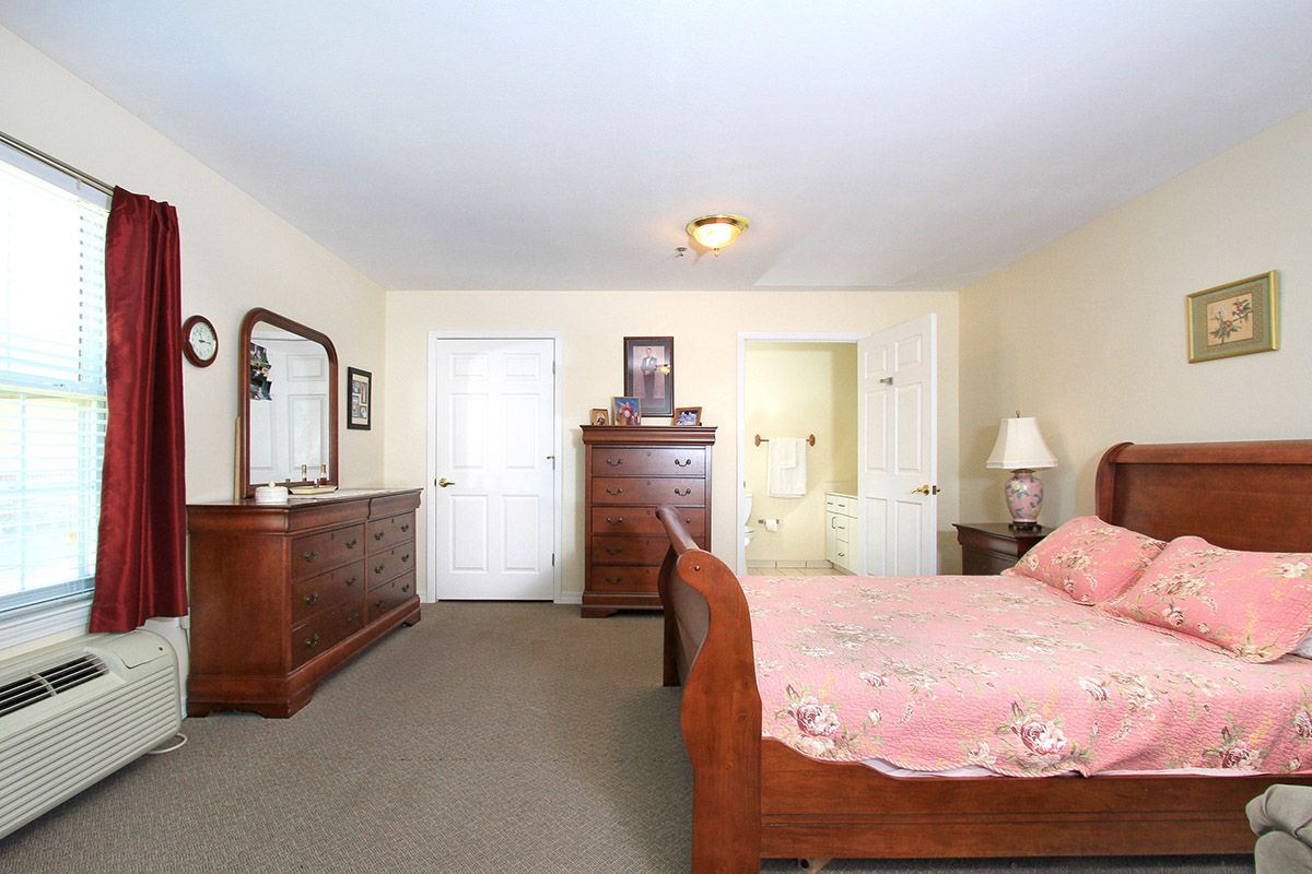 A vintage-style bedroom featuring wooden furniture and a large mirror.