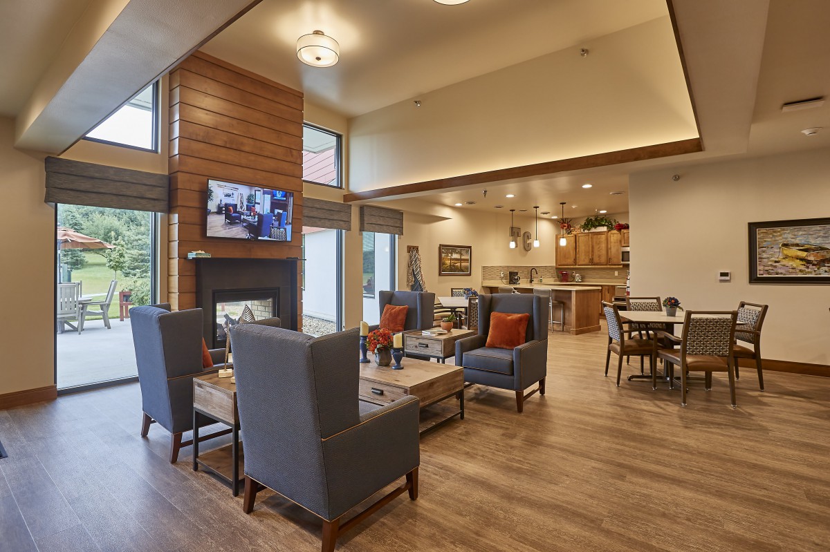 A modern living area with comfortable seating, a fireplace, and an open kitchen layout.
