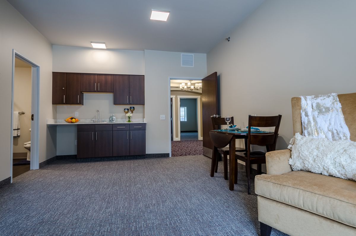 A modern apartment interior featuring a small kitchenette and dining area.