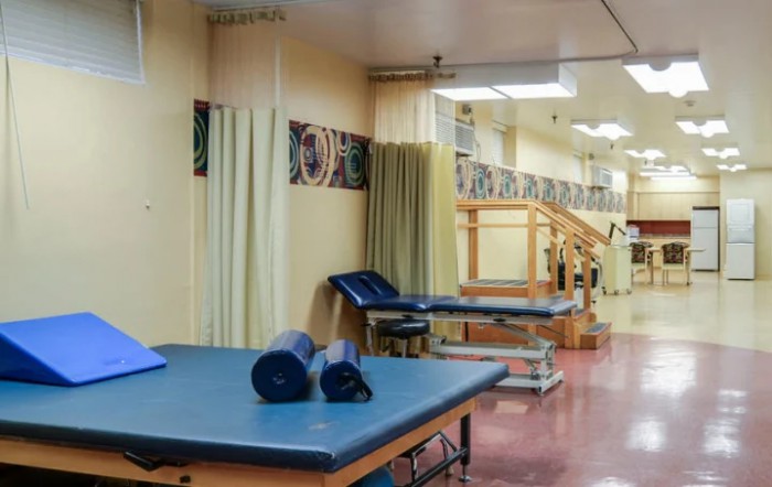 A physical therapy center with treatment tables and exercise equipment.
