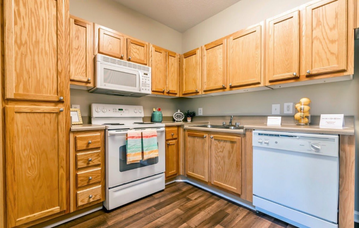 A modern kitchen with wooden cabinets and essential appliances.
