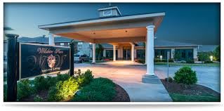 A welcoming hotel entrance with a covered walkway, illuminated during the evening.