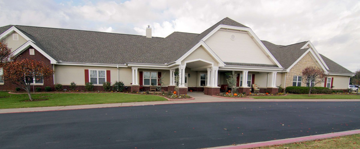 A suburban residential building with a well-maintained lawn and driveway.