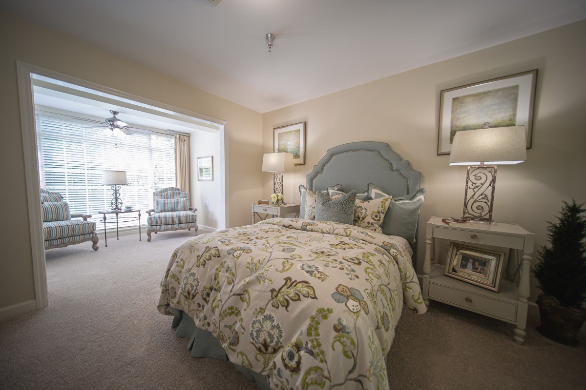 A cozy and elegantly decorated bedroom with a plush bed, stylish bedding, and ambient lighting.