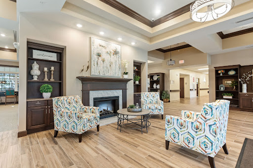A modern and cozy lobby area featuring stylish seating, a fireplace, and decorative artwork.