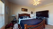 A cozy bedroom with a large bed, wooden furniture, and modern decor.