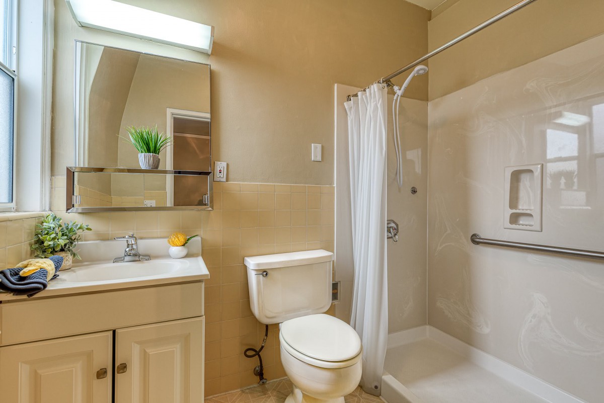 A clean and modern bathroom with a shower, sink, and toilet.