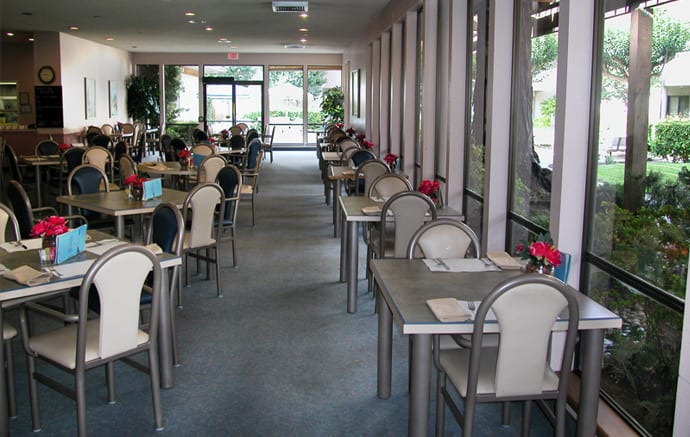 An empty restaurant dining area with neatly arranged tables and chairs.