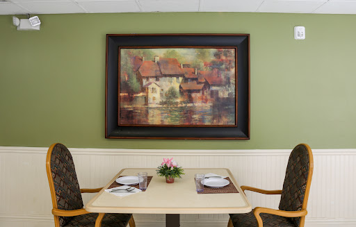 A cozy dining area featuring a beautiful painting and a neatly set table.