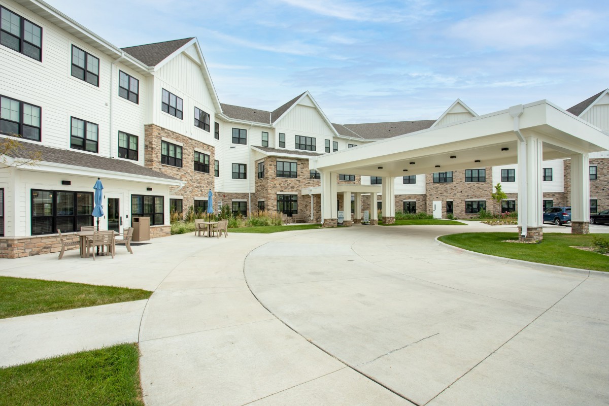 Exterior view of a multi-story residential building with landscaped surroundings.