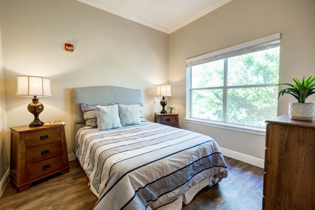A cozy bedroom with a neatly made bed and soft lighting.