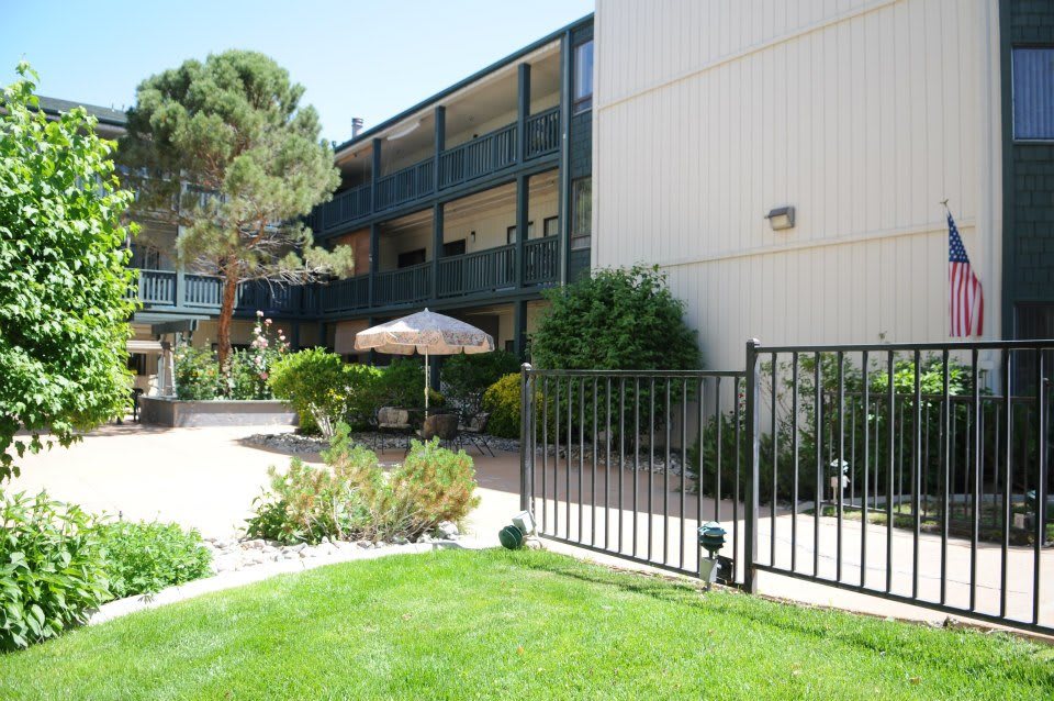 A view of an apartment building with balconies and a landscaped garden area.