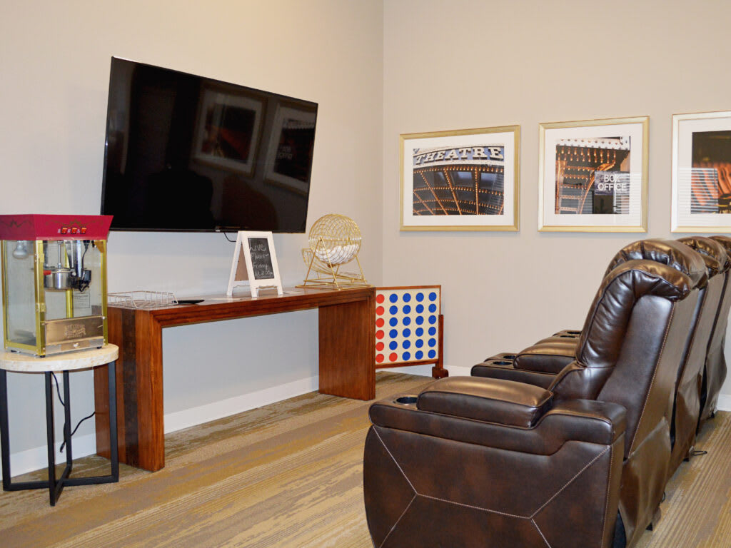 A cozy living room setup with plush reclining chairs facing a mounted television, complemented by tasteful decor.