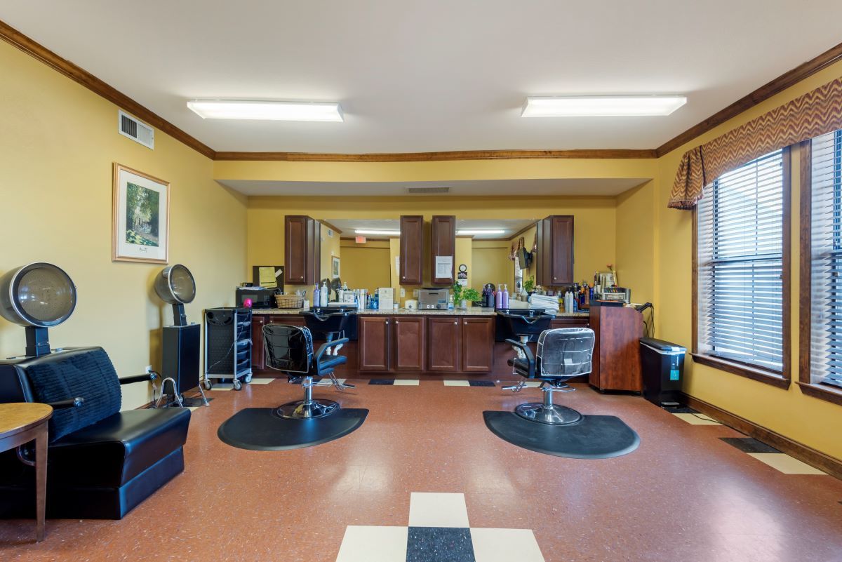 An empty barbershop with chairs and mirrors arranged neatly.