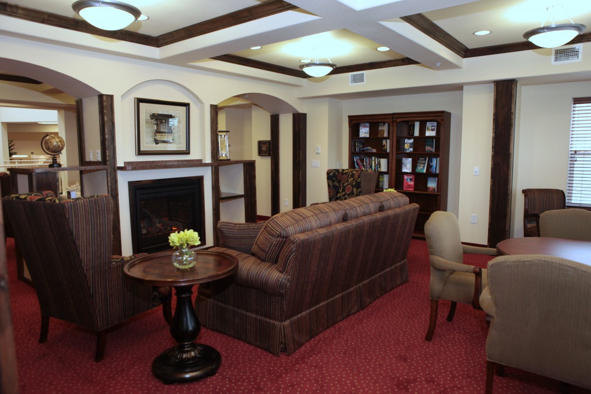 A cozy living room featuring a plush sofa, bookshelves, and a fireplace.