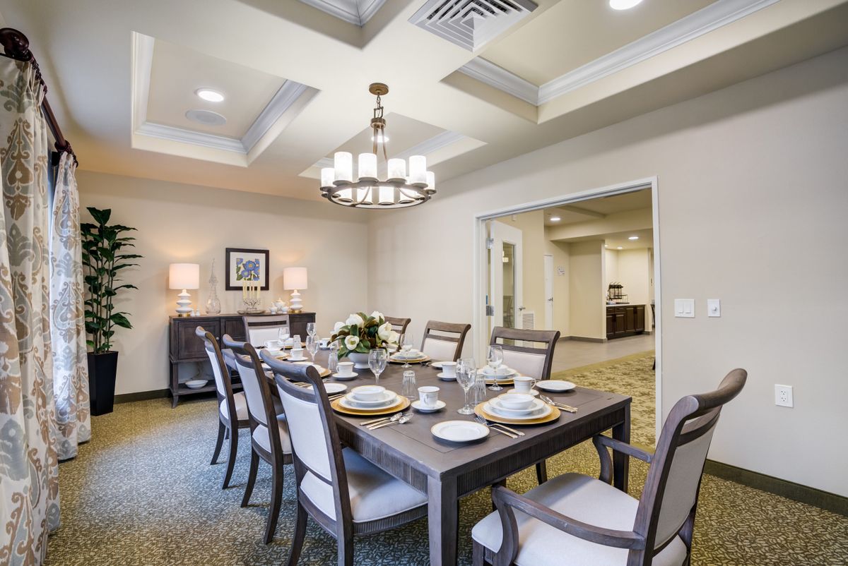 A modern dining room with elegant table settings and a stylish chandelier.