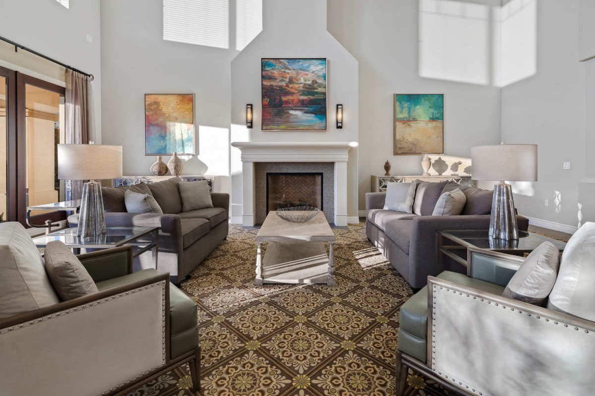 A stylish living room with a central fireplace, modern sofas, and decorative artwork.