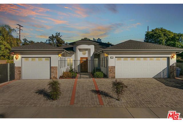 A suburban house with dual garages, captured during sunset.