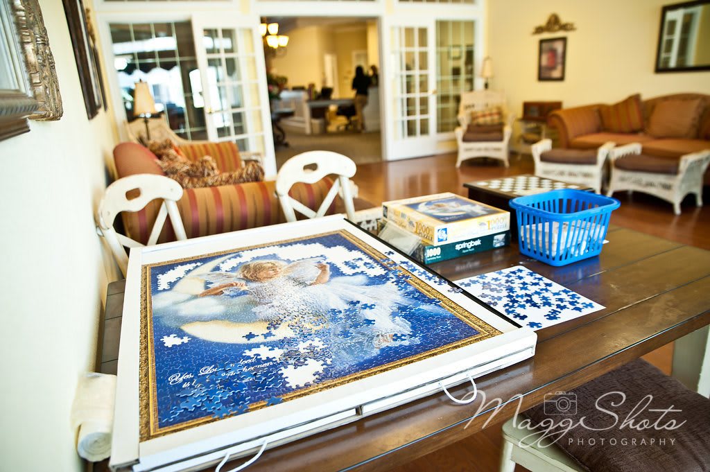 A cozy living room with a puzzle in progress on the table.