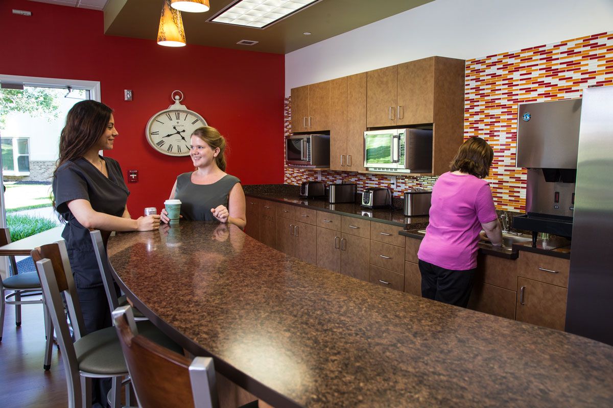 People enjoying a conversation in an office break room.