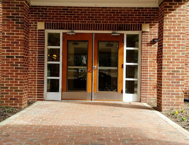 A symmetrical entrance with double doors and brick walls.