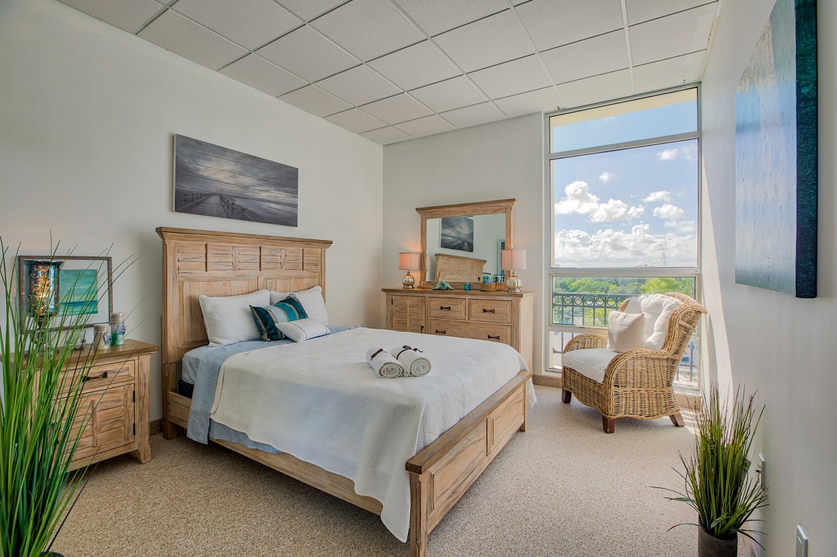 A cozy bedroom with natural light and a scenic view.