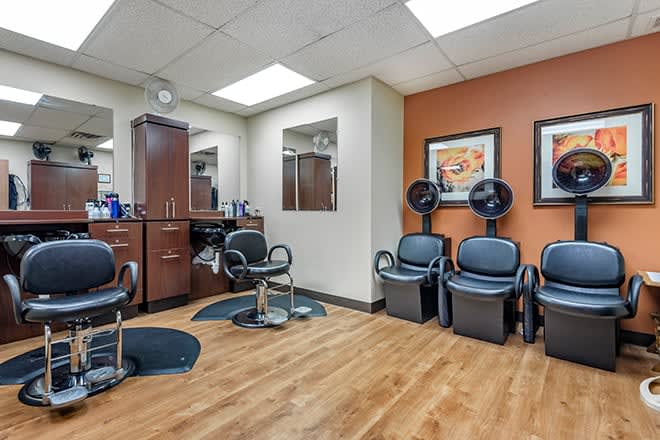 A well-equipped salon interior with styling chairs and hair dryers.