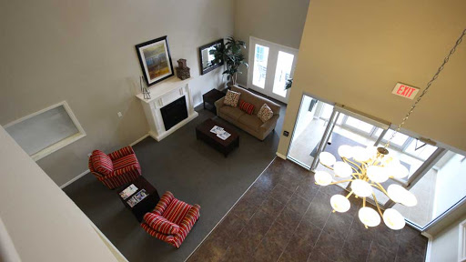 A cozy living room featuring comfortable seating, a fireplace, and large windows that fill the space with natural light.
