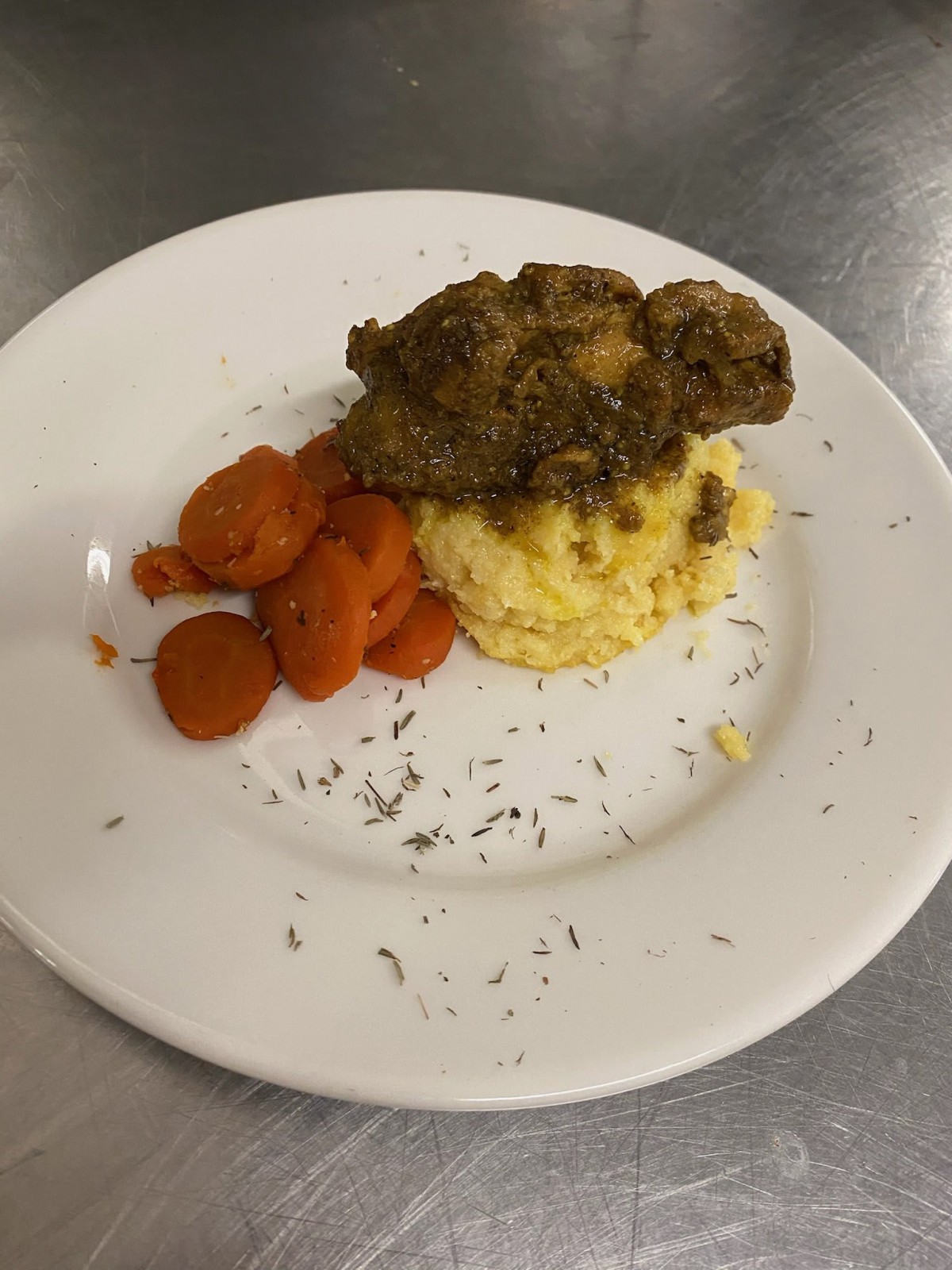 A plated dish featuring crispy chicken, mashed potatoes, and sliced carrots.