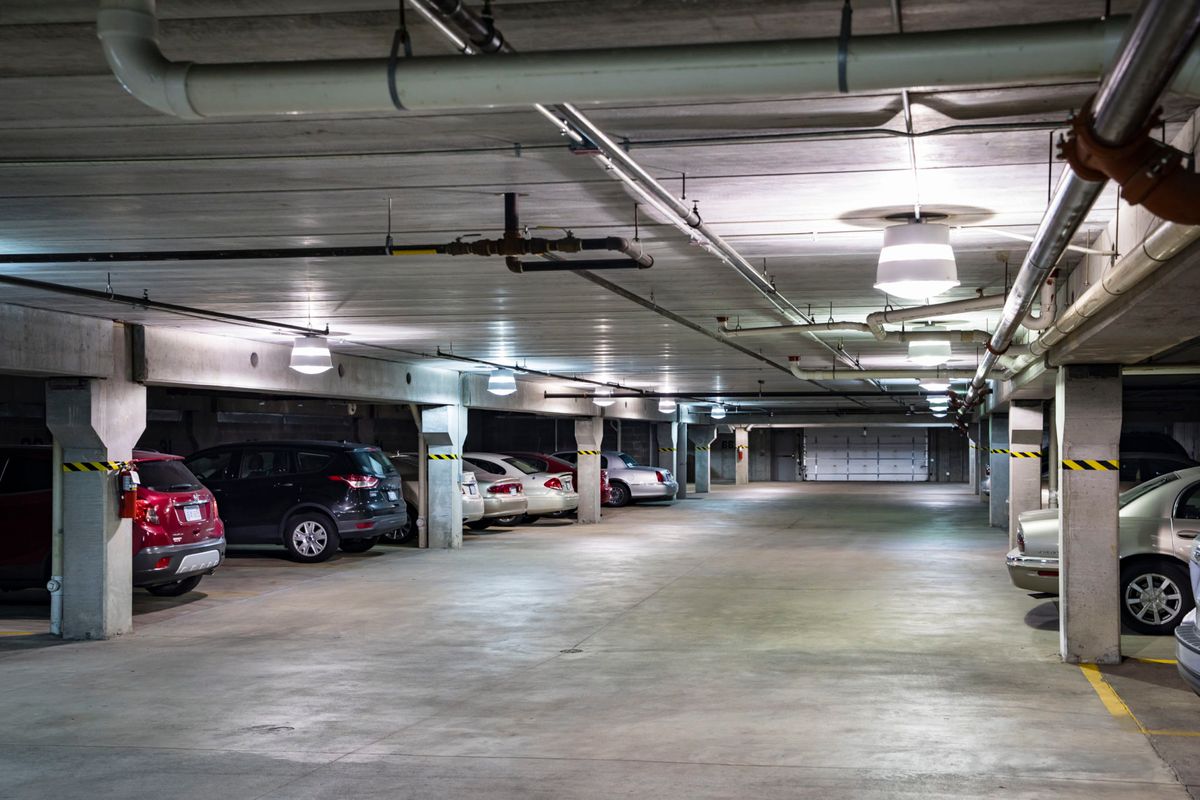 An indoor parking garage with several parked cars and empty spaces.