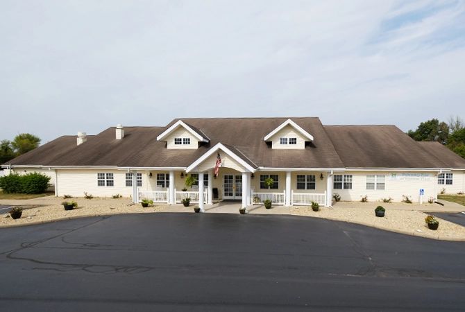 A large residential house with a wide porch and multiple windows.