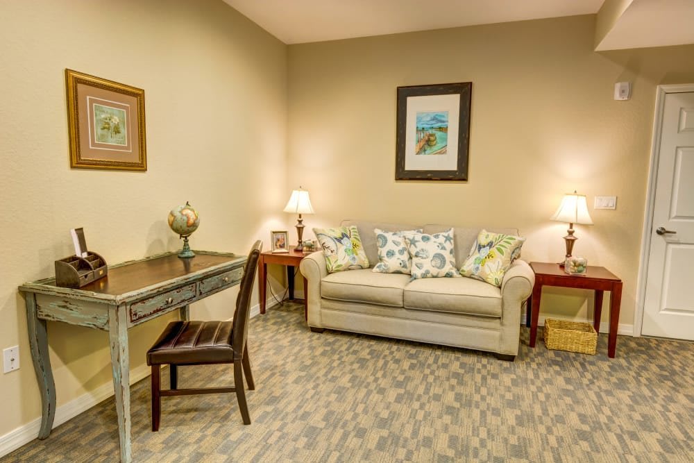 A cozy living room with a sofa, desk, and decorative lighting.