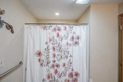 A bathroom with a floral shower curtain.