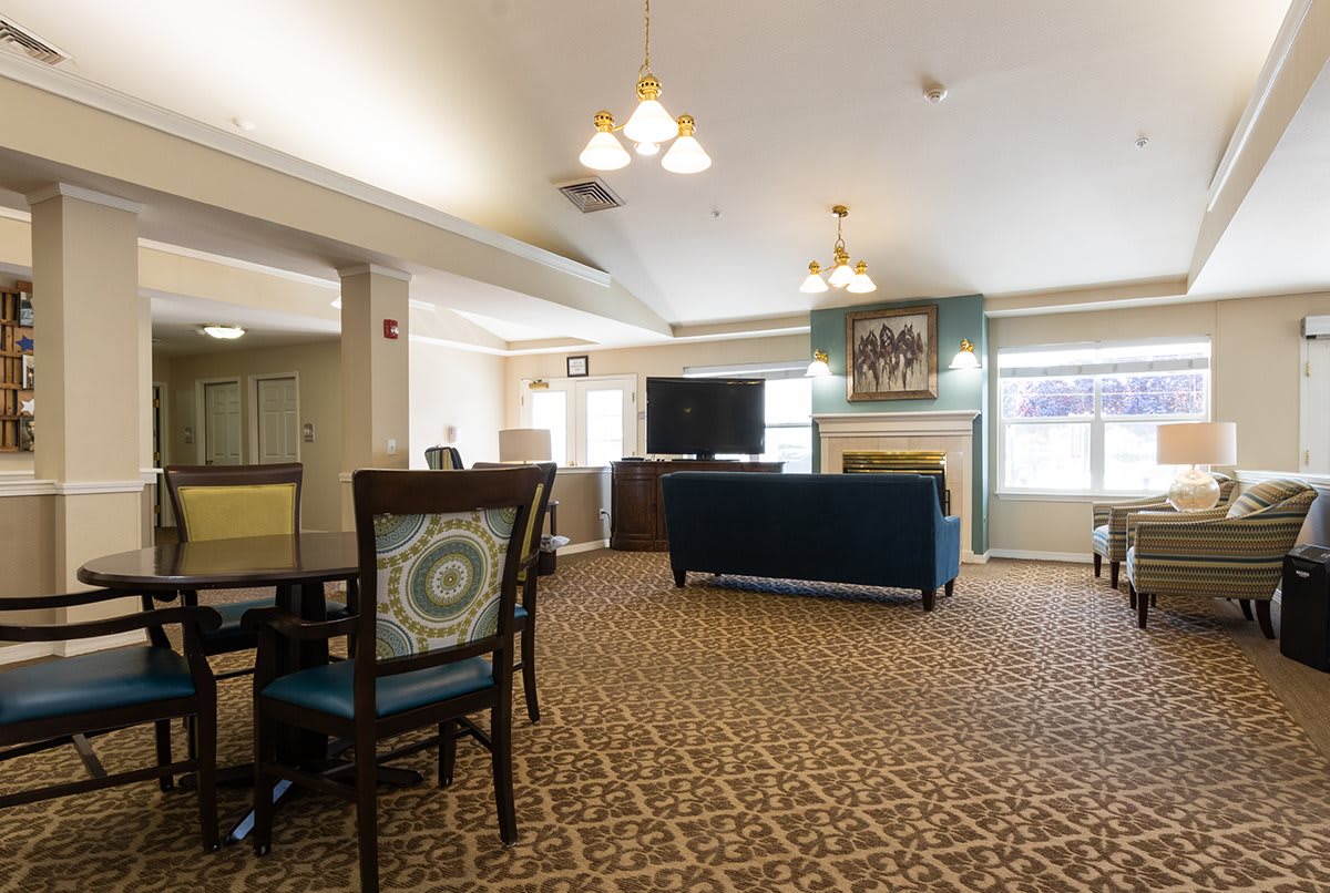 A spacious living room with comfortable seating, a television, and a fireplace.