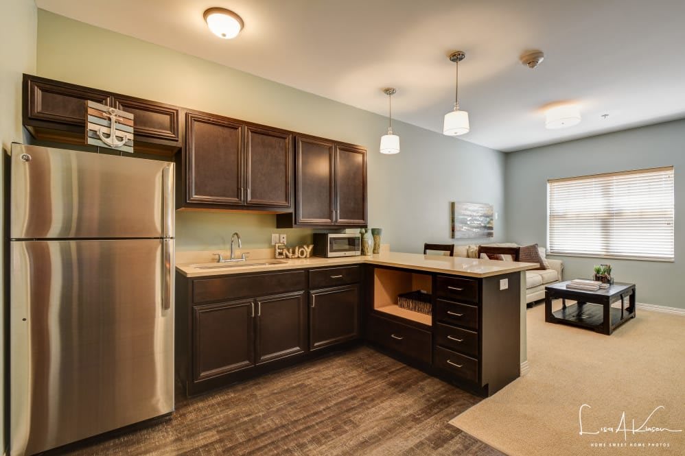 Modern kitchen in an apartment with wood cabinets and stainless steel appliances.