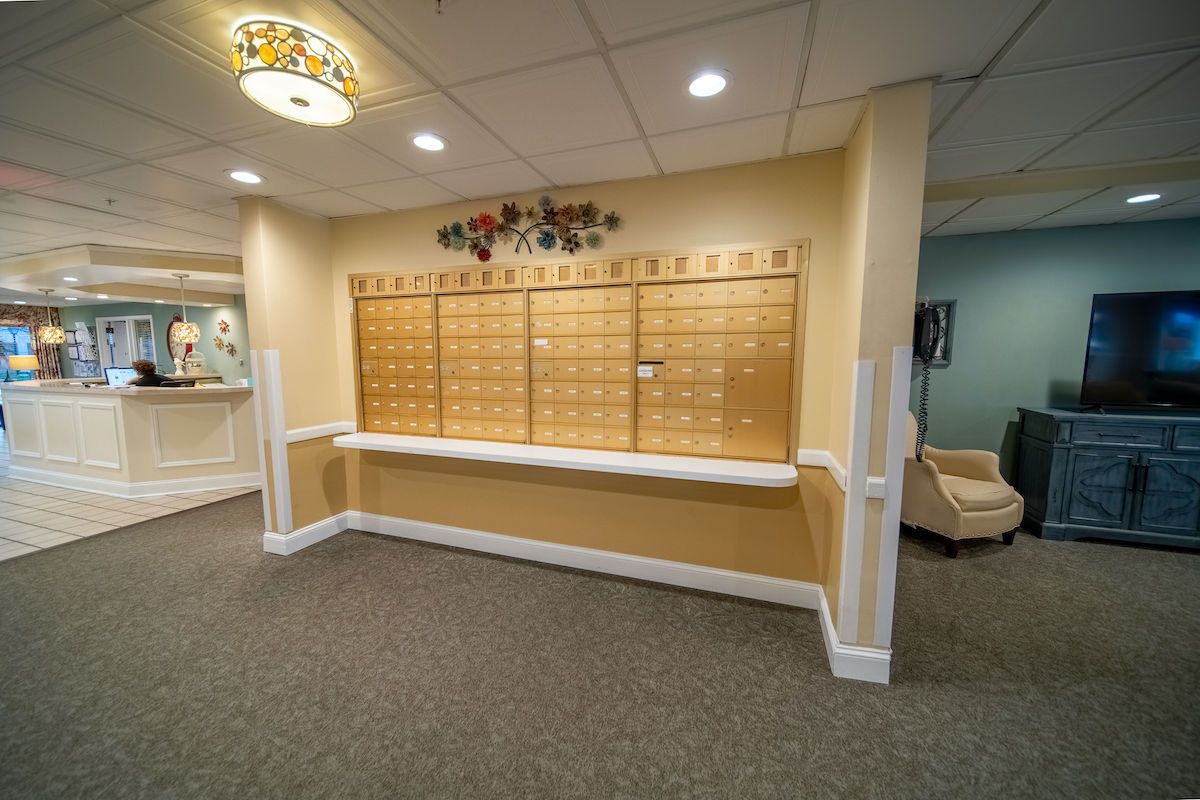 A mailroom with a wall of mailboxes in an office building lobby.
