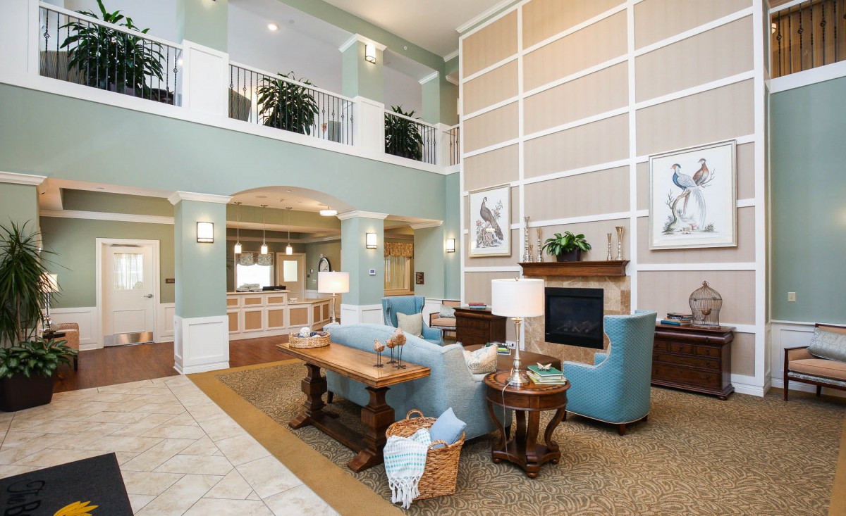 A spacious and elegantly designed living room with modern furniture and a warm fireplace.