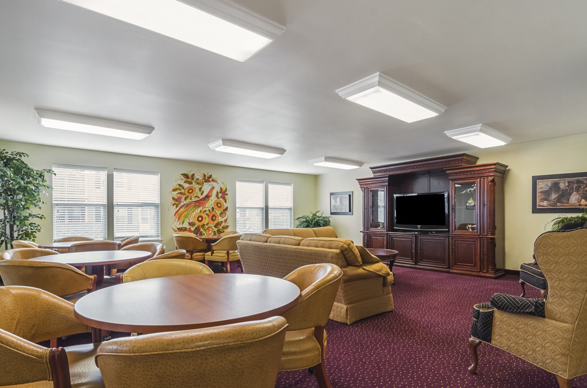 A cozy lounge area with comfortable seating, tables, and a television.