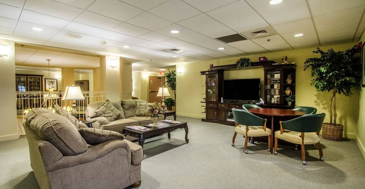 A cozy living room with comfortable seating, a large television, and warm lighting.