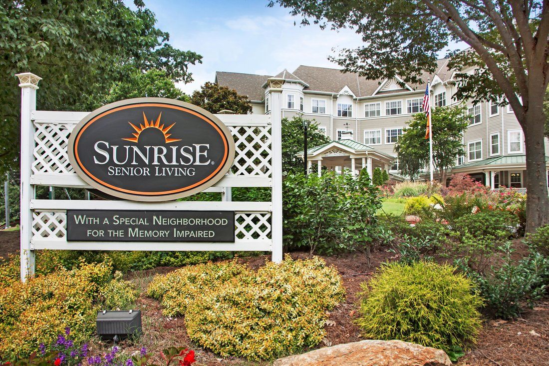 A well-landscaped entrance to a retirement home with a prominent sign.