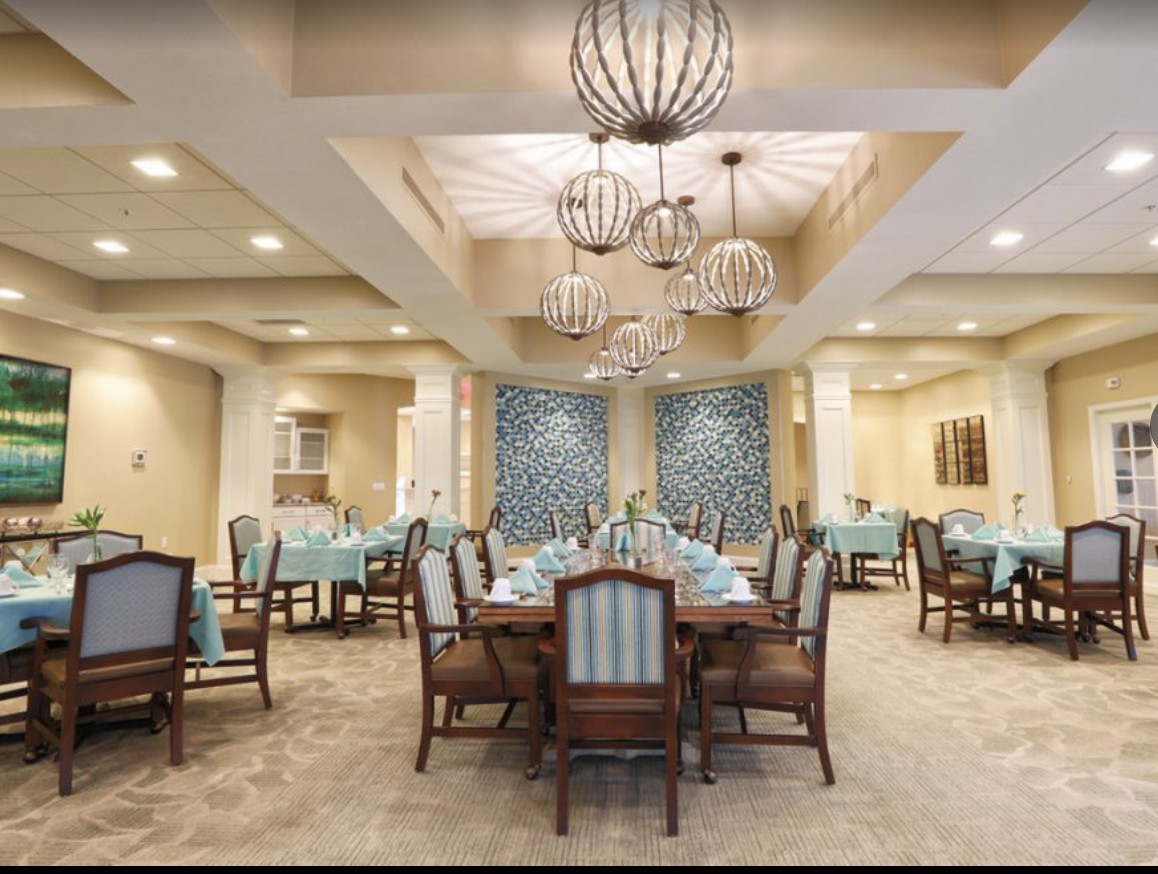An elegant dining room with sophisticated chandeliers and neatly arranged tables set for guests.