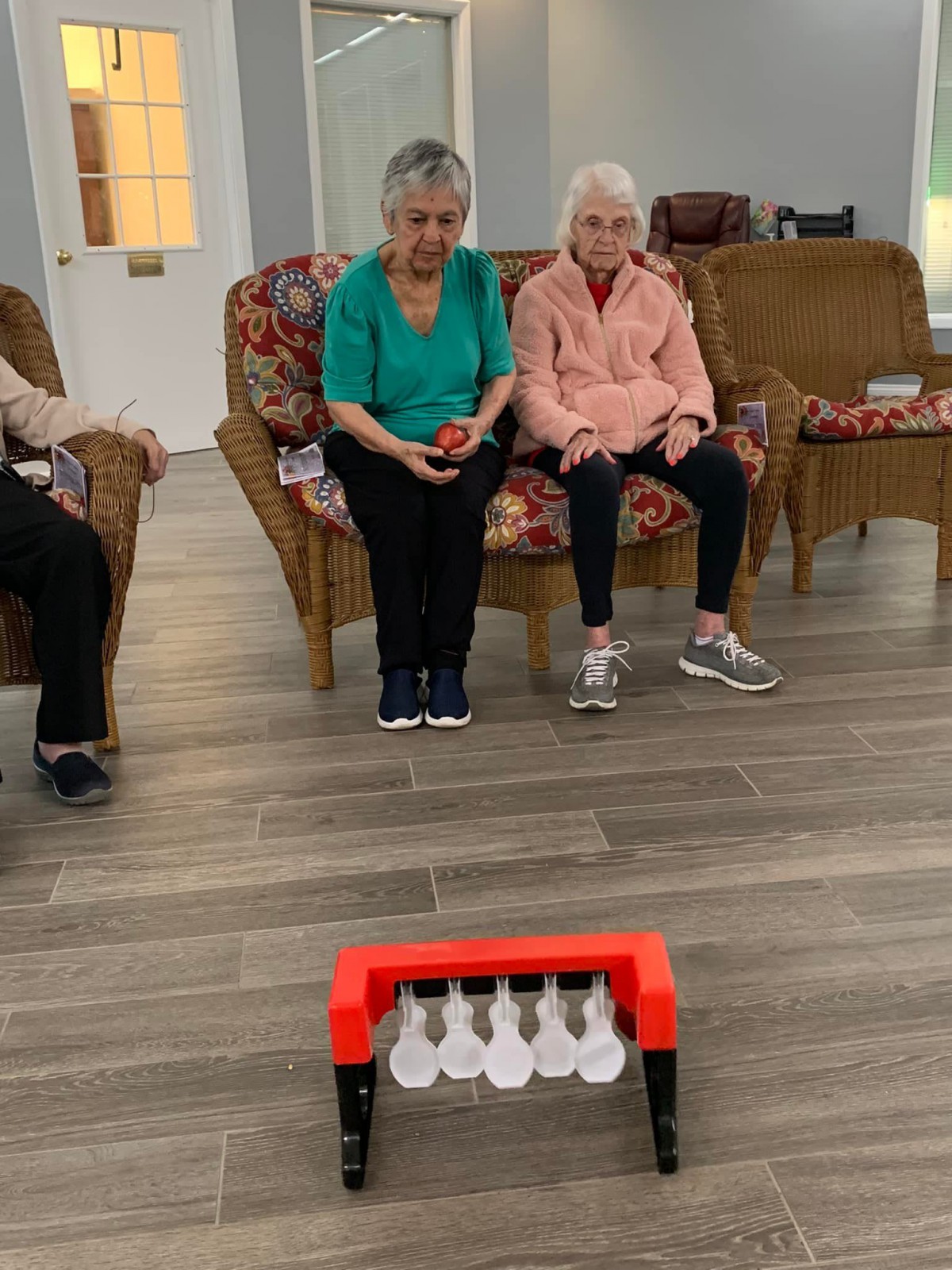 Seniors enjoying an indoor bowling game at a community center.