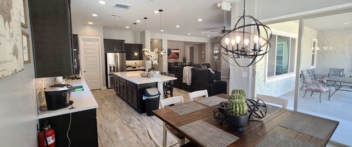 A modern open-concept living space with a kitchen and dining area featuring sleek decor elements.