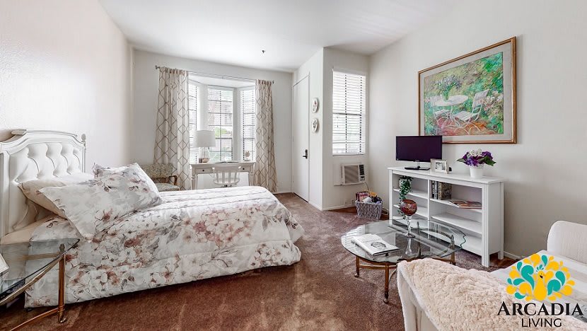 A cozy bedroom with floral bedding, ample natural light, and stylish decor.