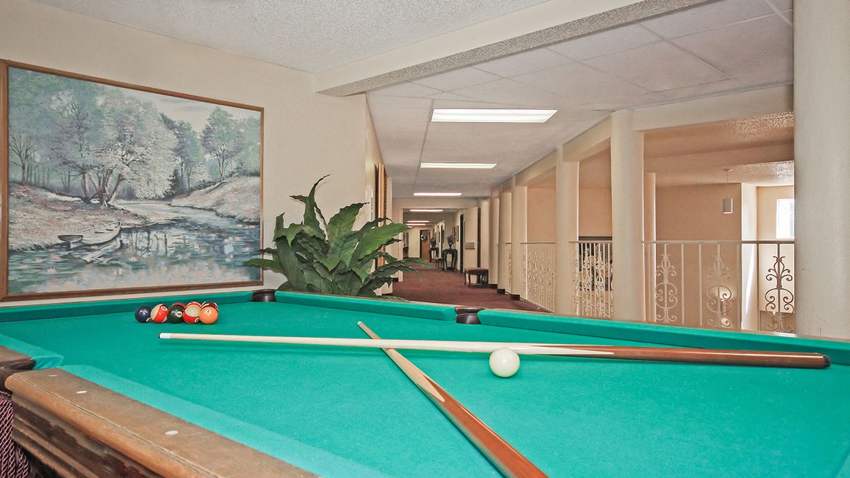 A pool table located in a spacious hallway, ready for a game.