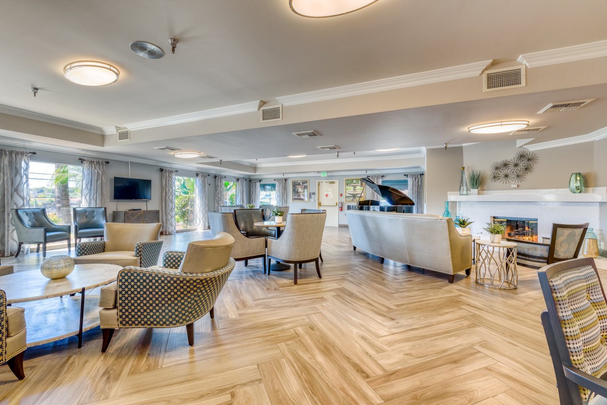 A spacious and modern living room with elegant furniture, a grand piano, and large windows allowing natural light to flood in.