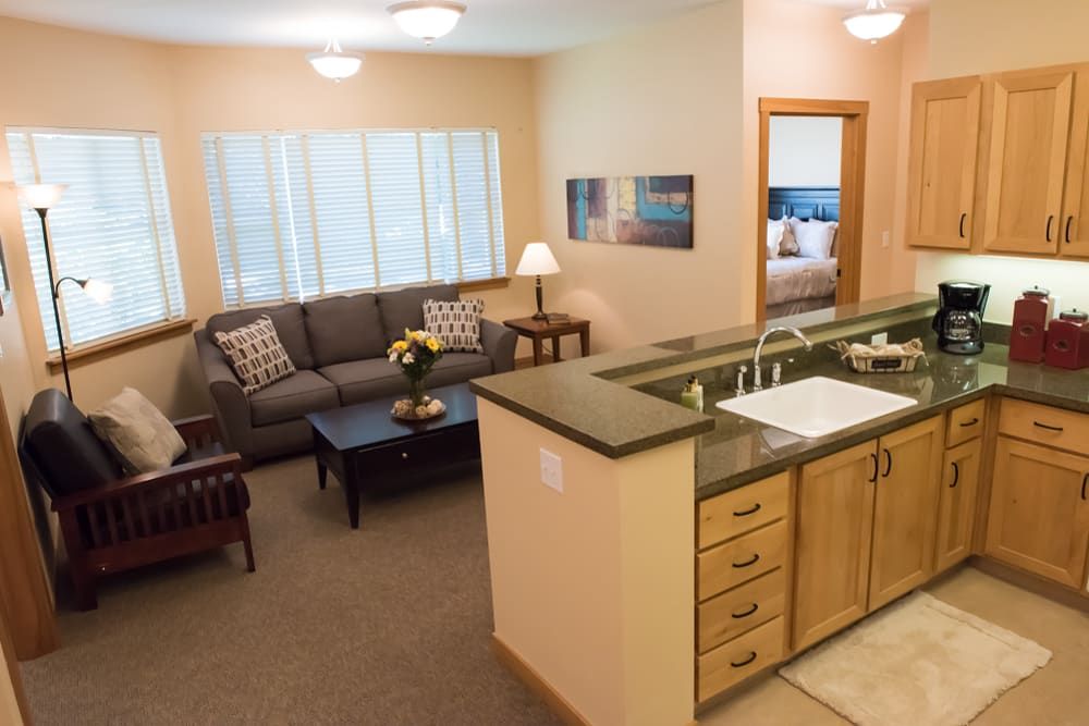 A cozy apartment interior featuring a modern open-plan living area with a kitchen and comfortable seating.