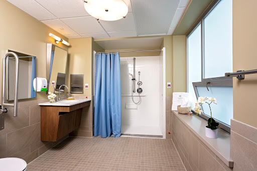 A modern bathroom featuring a shower, vanity area, and plenty of natural light.