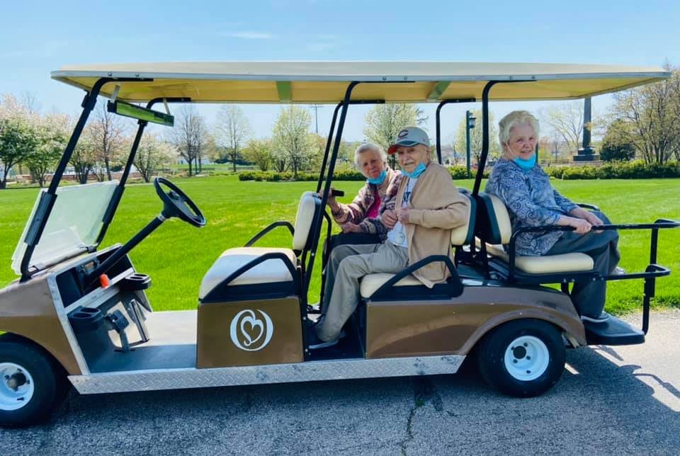A group of people enjoying a ride on a golf cart on a sunny day.