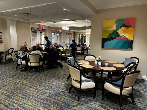 A lively dining area with patrons enjoying their meals and staff attending to them.